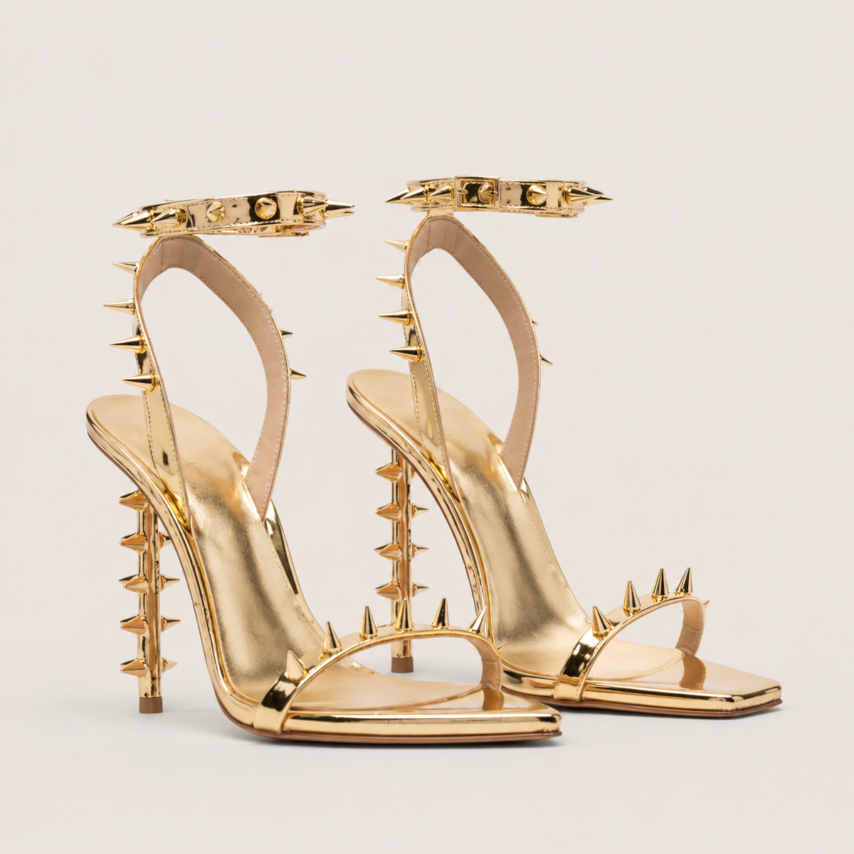Gold pointed-toe high heel sandals with rivet buckle detail